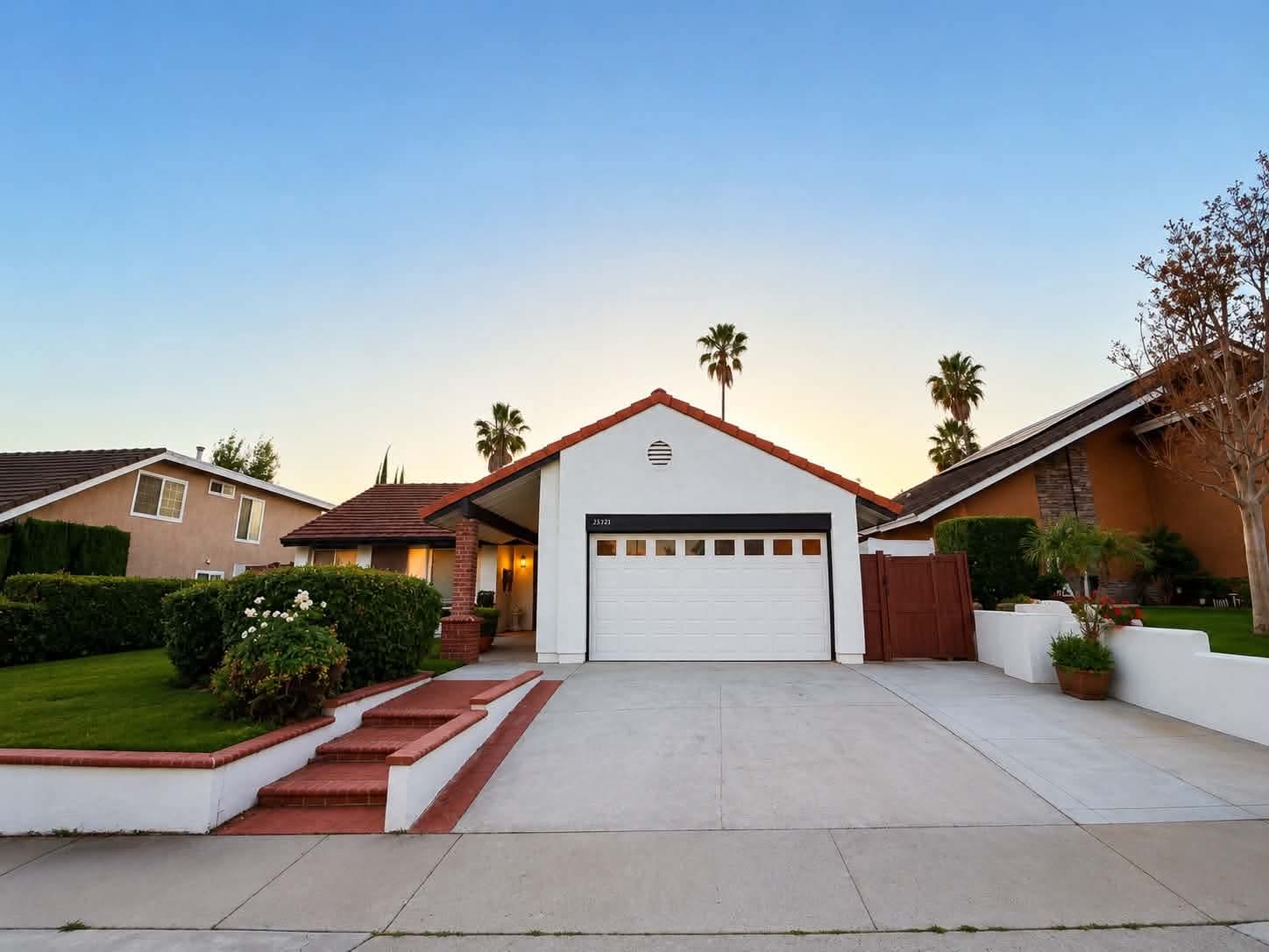 The Tessa Place 2 home in Laguna Hills at golden hour, with palm trees and tile roof.